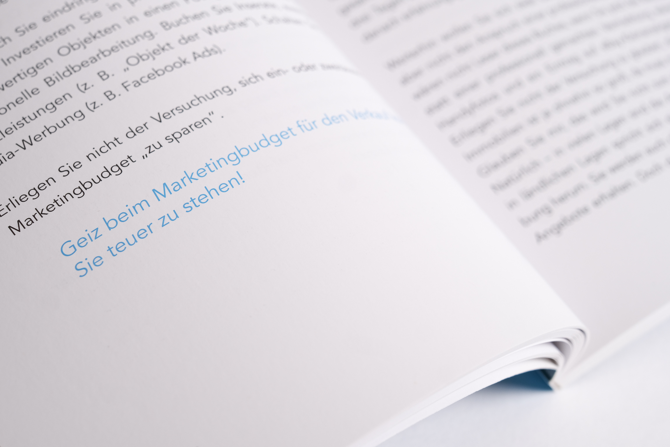 Offenes Buch mit deutschem Text und blau markierter Passage Offenes deutsches Buch mit blau markiertem Text auf weißer Seite in Nahaufnahme.