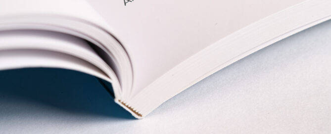 Offenes Taschenbuch auf heller Fläche mit sichtbarem Text und weichem, natürlichem Licht.