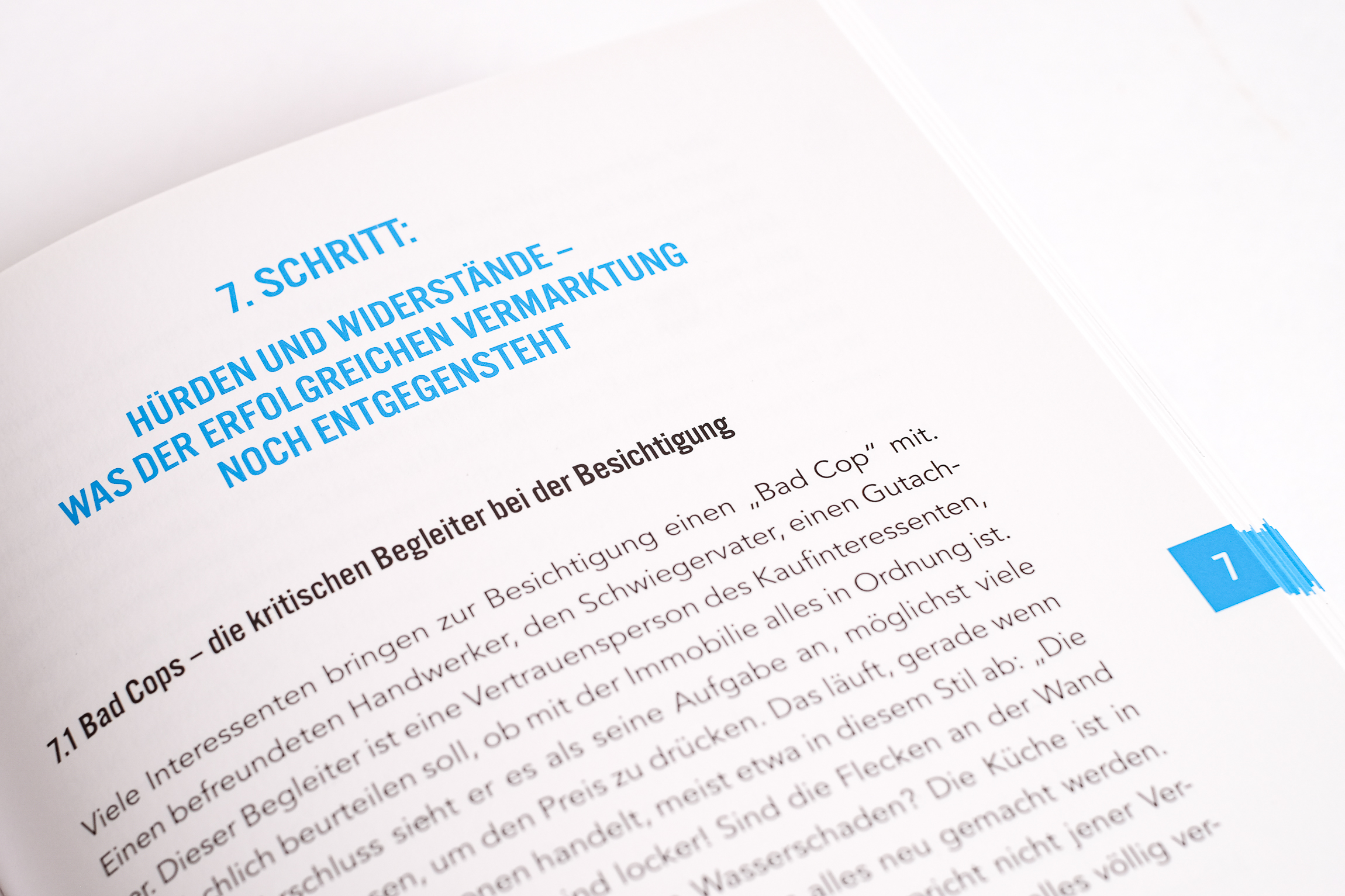 Offenes Buch mit Kapitelüberschrift zu Marketing-Hürden Offenes Buch von Johanes Heller mit deutschsprachiger Seite „7. SCHRITT: Hürden und Widerstände“ in blauem Textlayout.