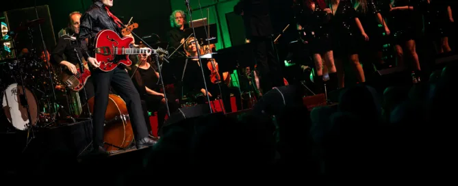 Elvis Show Frankfurt Alte Oper mit Gitarrist, Orchester und Sängern auf beleuchteter Bühne.