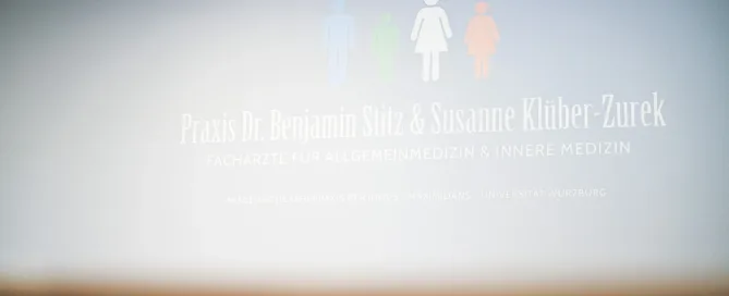 Praxisschild von Dr. Benjamin Stitz und Susanne Klüber-Zurek in Würzburg mit Familien-Symbolen.