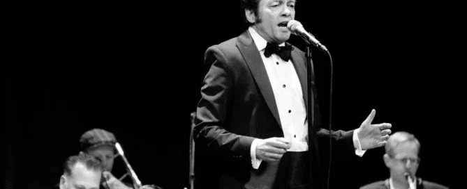 Sänger im Smoking mit Jazzband Blue Sky Orchestra auf Bühne im Barocktheater Schwetzingen, schwarz-weiß Fotografie.