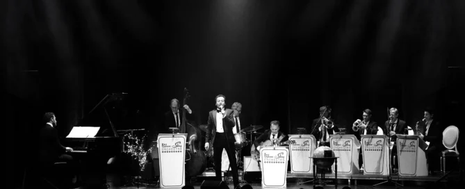 Jazzband mit Sänger im Anzug auf beleuchteter Bühne im Barocktheater Schwetzingen