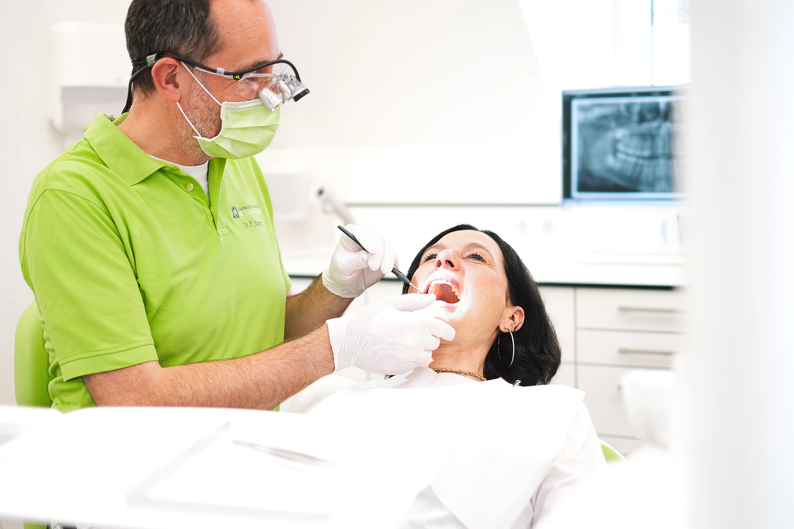 Moderne Zahnarztpraxis in Wuerzburg mit Patient und Zahnarzt Zahnarzt wendet sich einem Patienten in moderner Zahnarztpraxis in Würzburg.