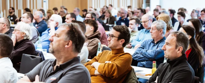 Teilnehmer eines Business-Events in Würzburg, fokussiert und aufmerksam während einer Konferenz.