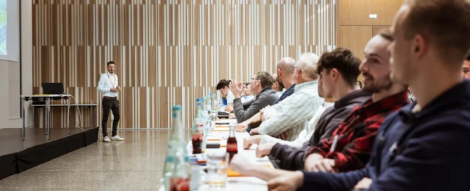 Geschäftliche Schulung: Teilnehmer im modernen Konferenzraum während Präsentation in Würzburg.
