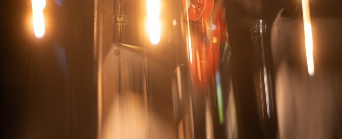 Gitarrist Chris Vega mit roter Gitarre, dramatischer Beleuchtung, verschwommene Bewegung.