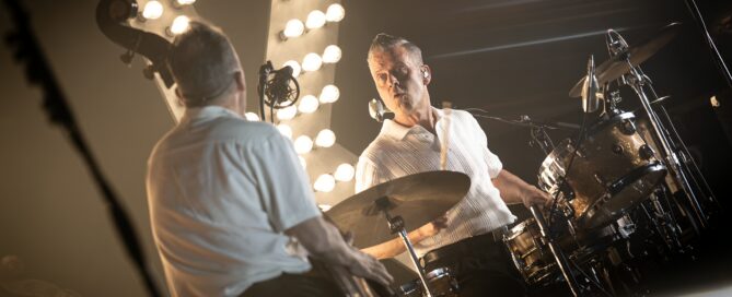 Zwei Musiker bei Live-Konzert in Frankfurt, Drummer im Fokus, Bühnenbeleuchtung und Atmosphäre.