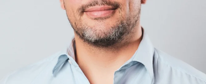 Professionelles Porträt eines Mannes in Business-Casual, blauer Hemd, neutraler Hintergrund, in Würzburg fotografiert.