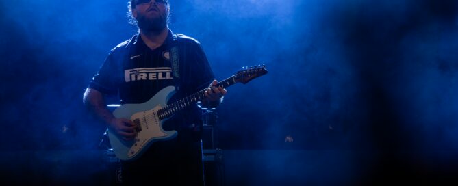 Gitarrist des Moses Yoofee Trios beim Hafensommer-Konzert in Würzburg im blauen Bühnenlicht.