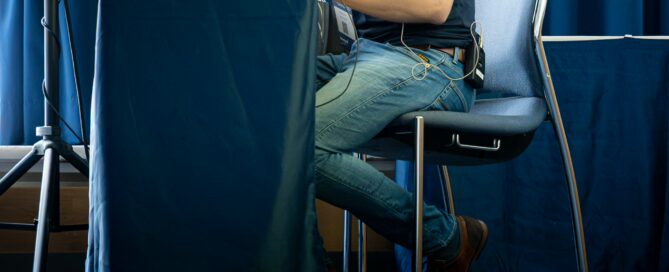 Mann mit Laptop im Veranstaltungsraum vor blauen Vorhängen in Würzburg